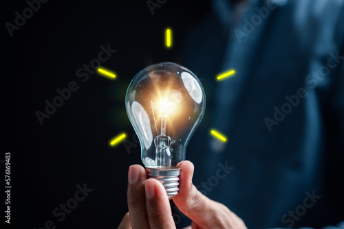 Hand man holding illuminated lightbulb, idea, innovation and inspiration with glowing virtual brain, smart intelligent creativity with bulbs, Motivation and innovation concept.