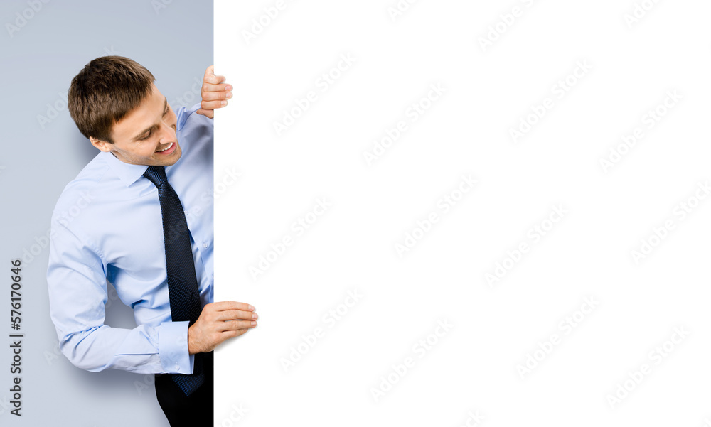 Portrait image of business man professional bank manager in confident cloth, tie. Businessman stand behind look at empty white banner signboard with copy space area. Isolate on grey gray background Portrait image of business man professional bank manager in confident cloth, tie. Businessman stand behind look at empty white banner signboard with copy space area. Isolate on grey gray background