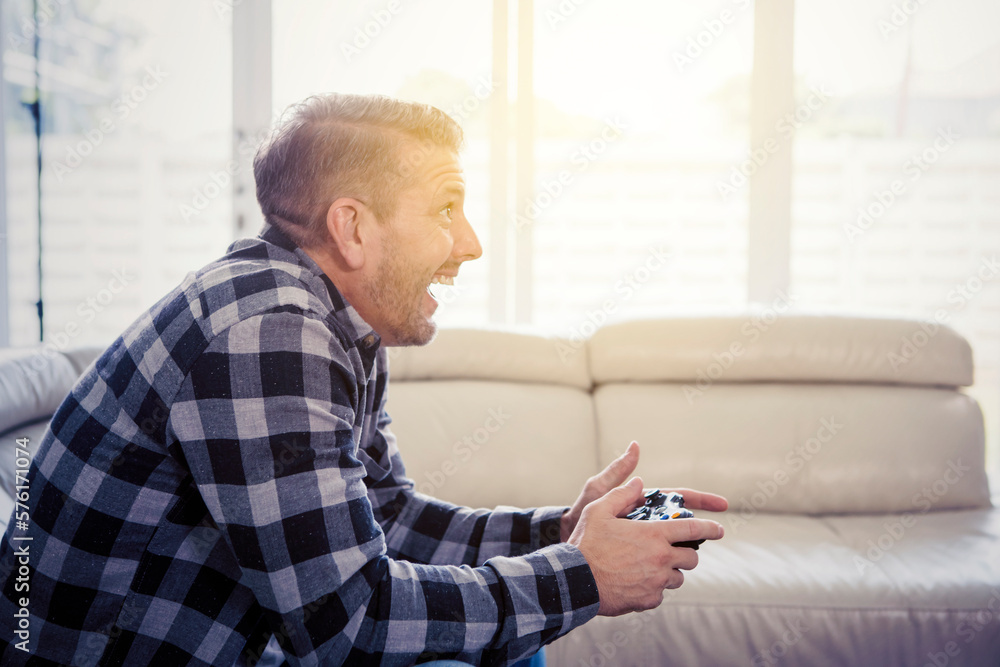 Excited or happy caucasian man playing game in his living room Excited or happy caucasian man playing game in his living room