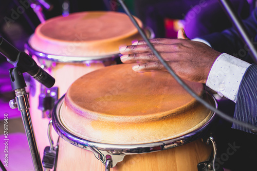Canvas Print Bongo drummer percussionist performing on a stage with conga drums set kit durin