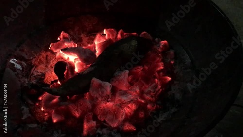 Roasting sweet potato on a red flamed charcoal on a new year event photo