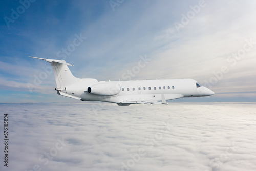 White luxury executive aircraft flies in the air above the clouds