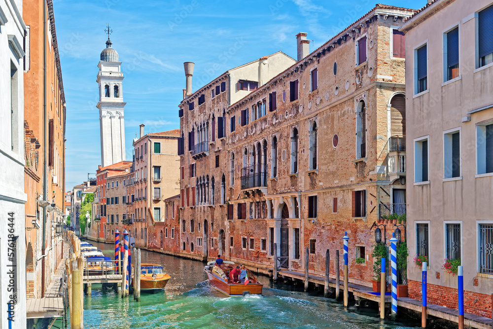 Canal with boats in Venice and Greek orthodox church San Giorgio dei Greci in the background. Boats and gondolas are the main transportation means in Venice
