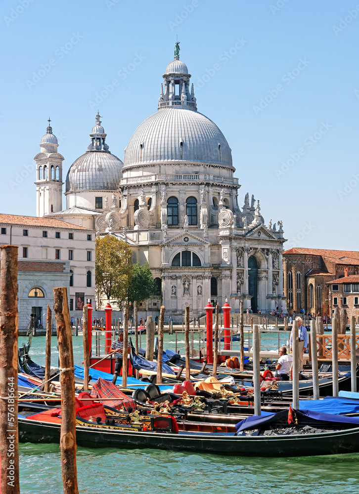 View of gondolas and Basilica di Santa Maria della Salute in Venice, Italy.This church was dedicated to Virgin Mary, who was thought to be a protector of the Republic