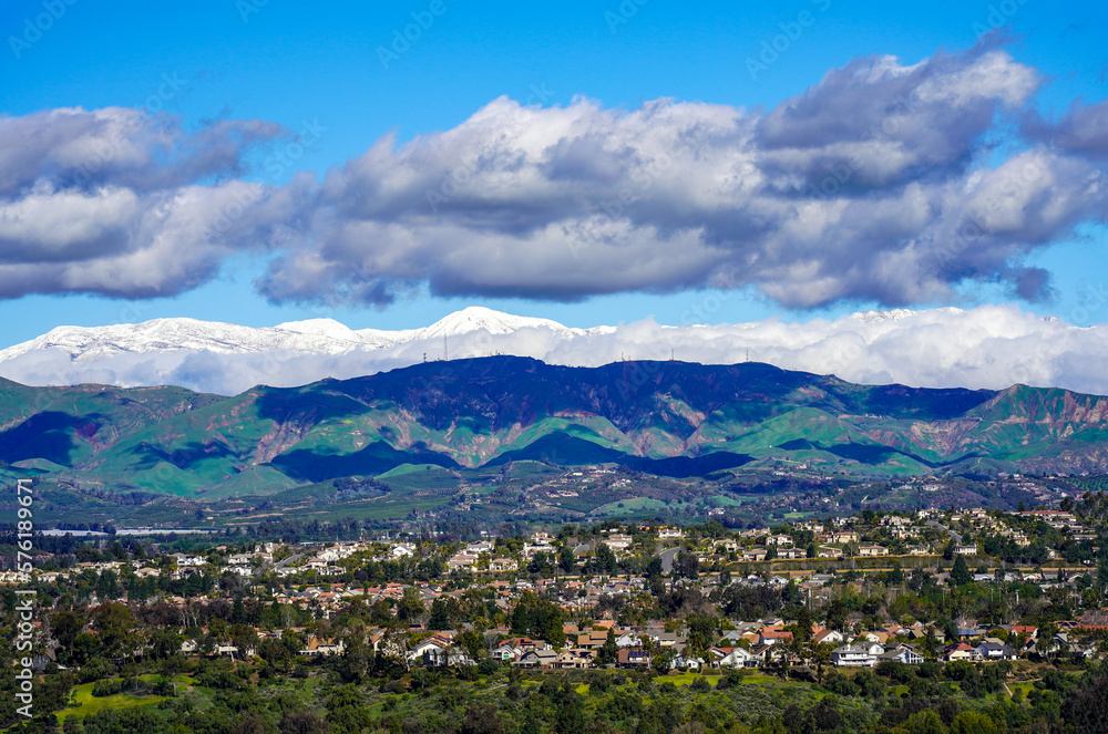 Panoramic Snow capped Conejo mountains in Ventura Southern California after historic 2023 snow fall and green hills Santa Rosa Valley with homes
