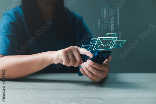 Photographie Woman using smartphone sends and receives email with envelopes icon for communicates with clients and friends online