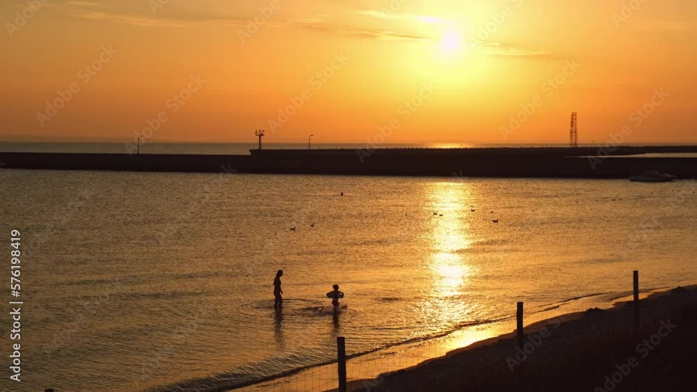 Reflection of sunlight over sea surface at sunset. Orange and gold blue sky. Scenic Gold sea. Dramatic Yellow sun coming out of the sea. Majestic summer landscape