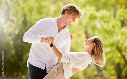 Couple, dance and love in park, garden and nature for love, romantic care and happiness together. Happy man, young woman and dancing outdoor in sunshine, summer date and celebration of valentines day