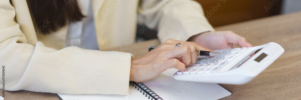 Fototapeta premium Work of secretary concept, Female secretary using calculator to calculate expenses of business
