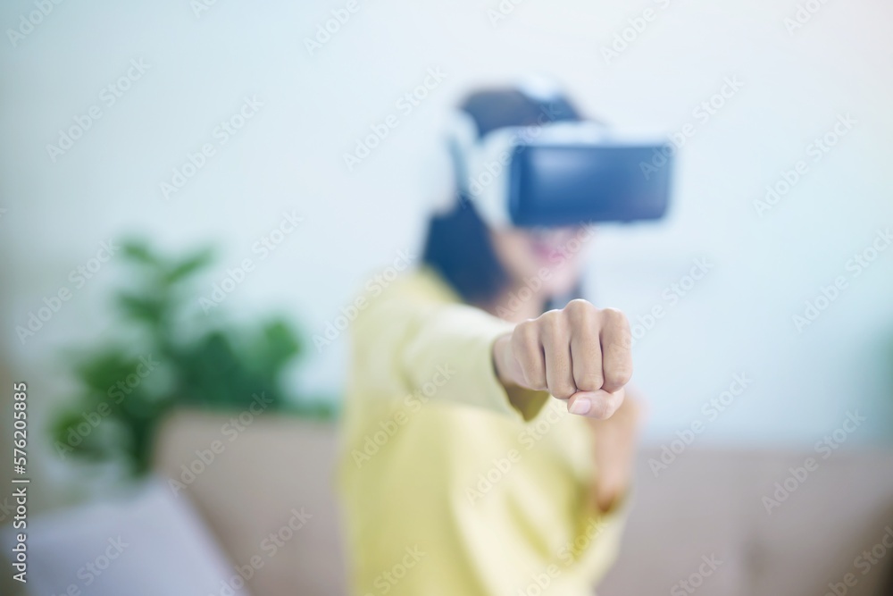 Young Asian woman wearing virtual reality touching air during the VR experience  Future technology concept