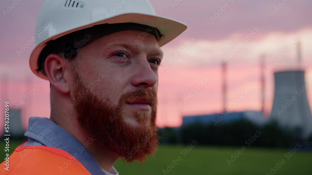 Portrait of a male engineer in a helmet and vest against the background of a power plant Portrait of a male engineer in a helmet and vest against the background of a power plant