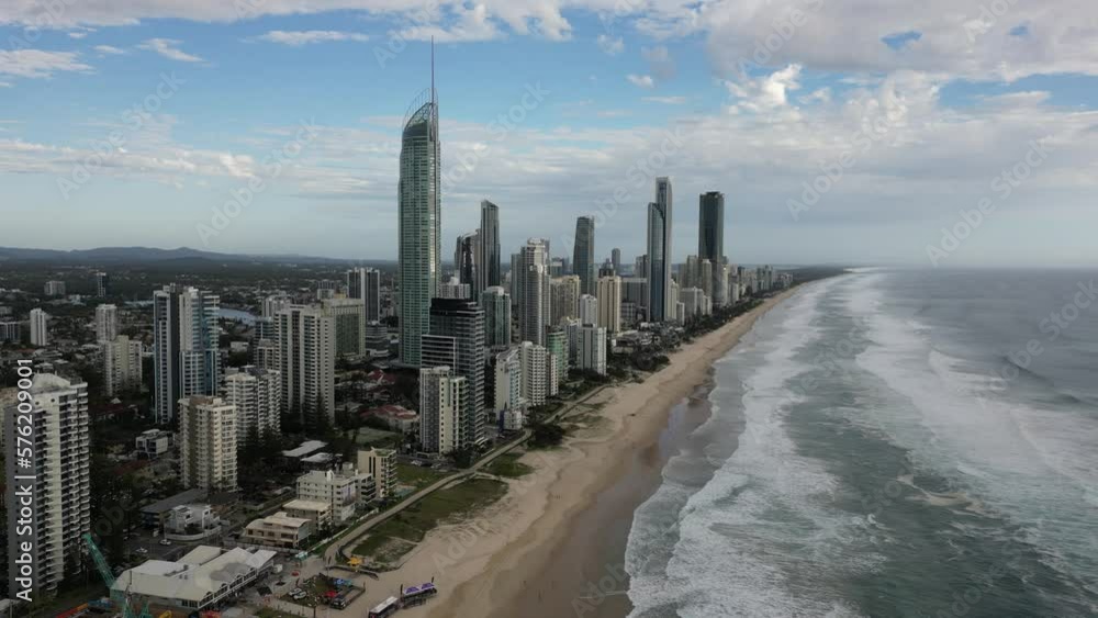 High rise apartment office tower building along a sandy beach with sea wave High rise apartment office tower building along a sandy beach with sea wave
