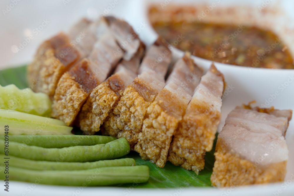 Deep-fried pork belly on a plate with fresh greens Deep-fried pork belly on a plate with fresh greens
