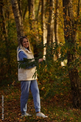 Photo of positive cheerful girl enjoy maple leaves in city center park woods