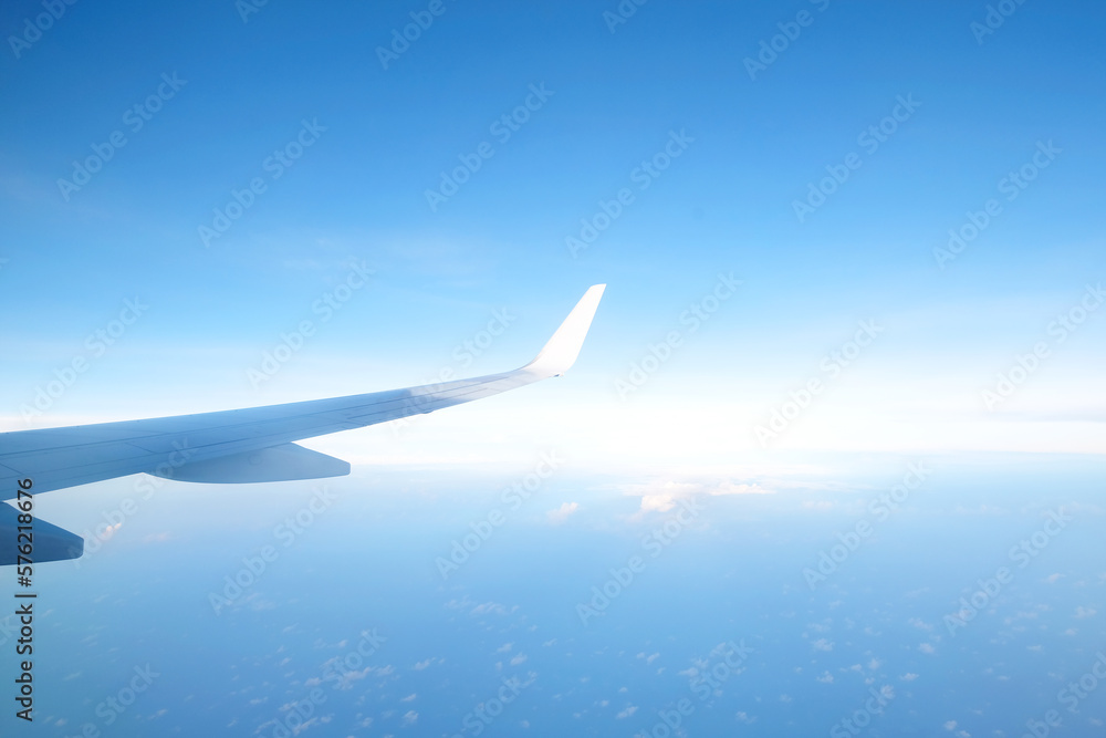 Aircraft wing flying above the beautiful clouds with sunlight in the morning. Traveling concept. Wing of an aircraft Aircraft wing flying above the beautiful clouds with sunlight in the morning. Traveling concept. Wing of an aircraft