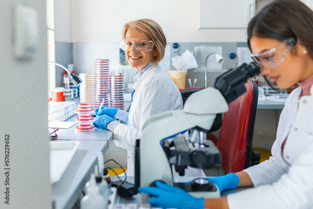Scientist in lab doing research and using lab machines, test tubes, microscope and every laboratory equipment Scientist in lab doing research and using lab machines, test tubes, microscope and every laboratory equipment