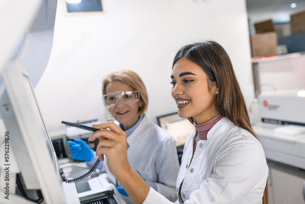 Obraz premium Two Research Scientists Talking about Programming Medical Equipment for Tests. Team of Professionals Doing Pharmaceutical Research in Modern Laboratory