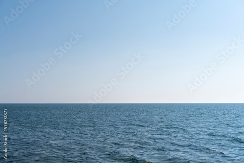 Aerial view of a blue sea water background and sun reflections. Aerial flying drone view. Waves water surface texture on sunny tropical ocean. Aerial photography.