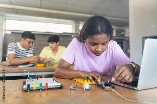 Black female teenager Student programming electronics robotics in the technology course photo