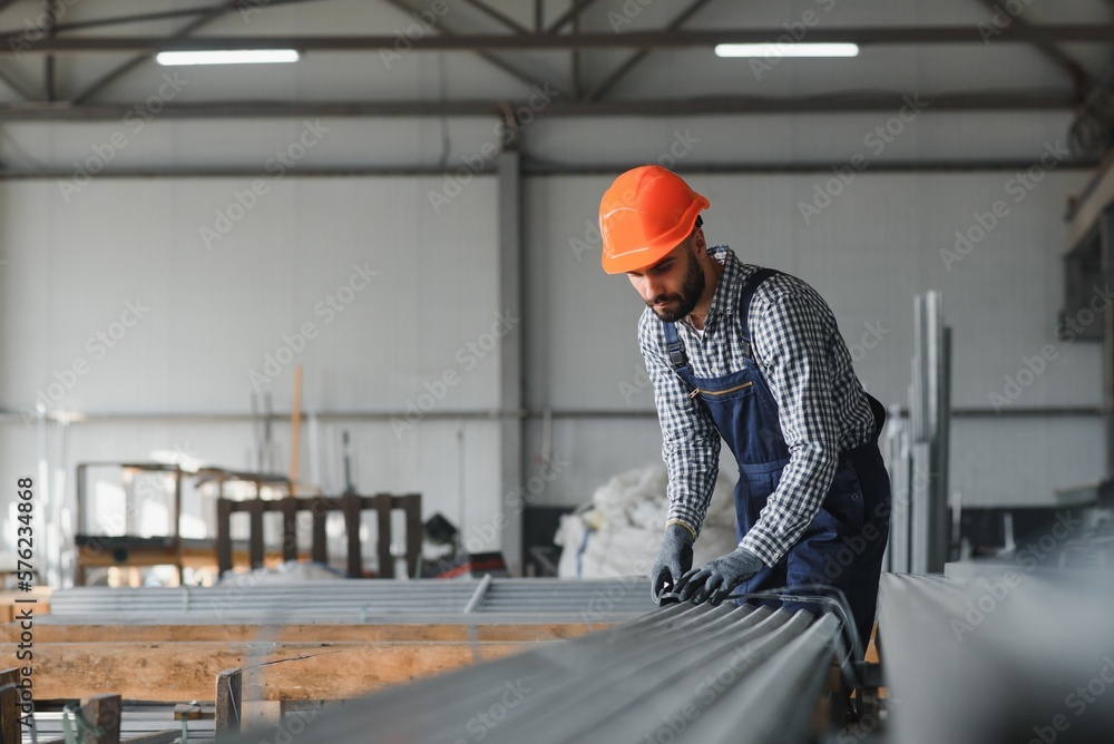Factory worker measures the metal profile Factory worker measures the metal profile
