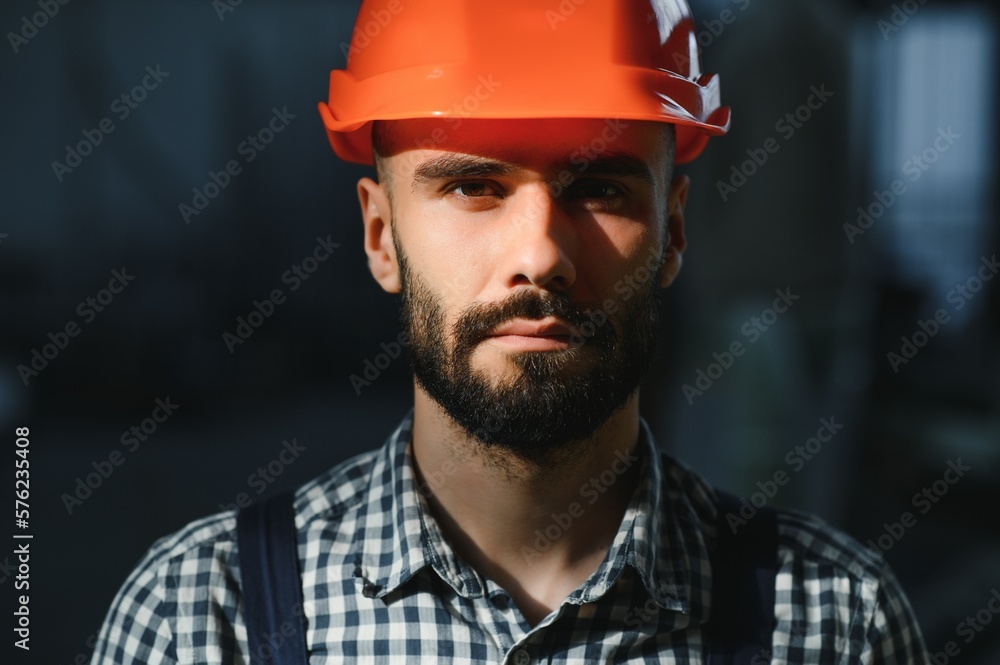 Portrait of industrial engineer. Factory worker with hard hat standing in factory. Portrait of industrial engineer. Factory worker with hard hat standing in factory.