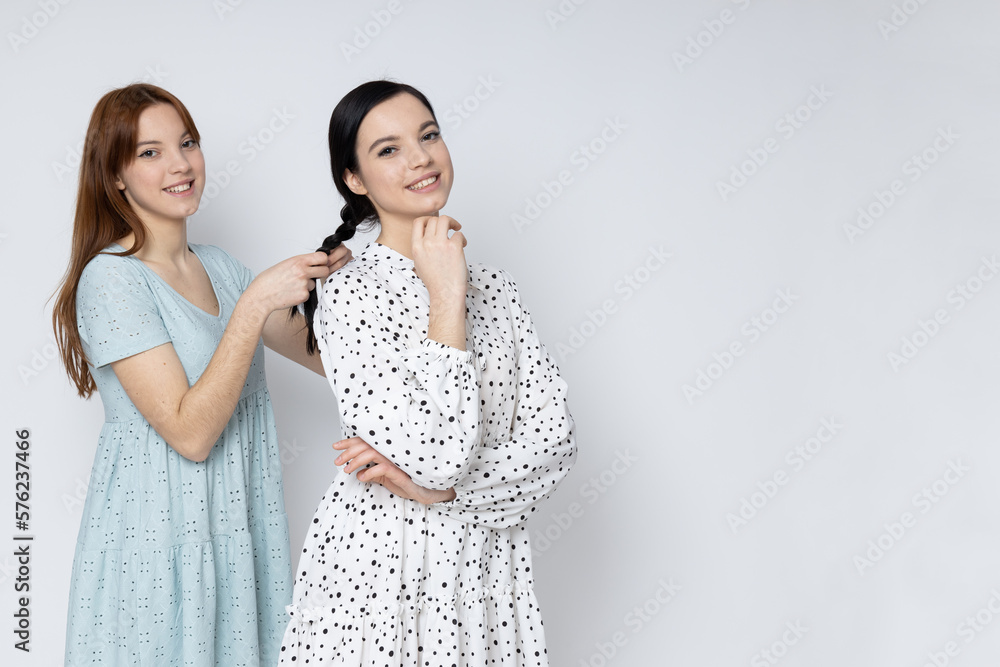 Two beautiful young women, sisters - twins on white background Two beautiful young women, sisters - twins on white background