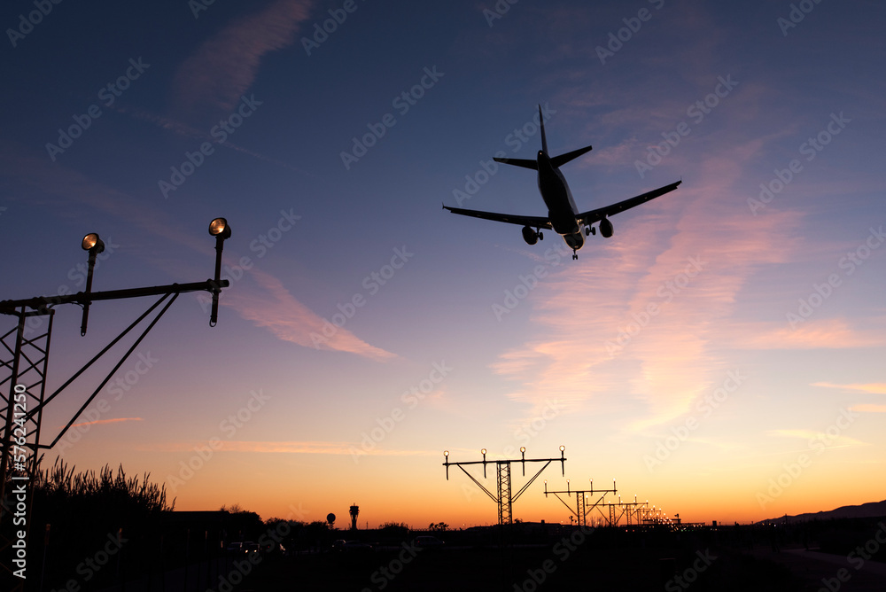 Flying airplane seen from below at sunset Flying airplane seen from below at sunset