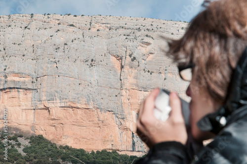 Woman drinking coffee near cliff of Roca dels Arcs, Vilanova de Meia, Catalonia, Spain photo