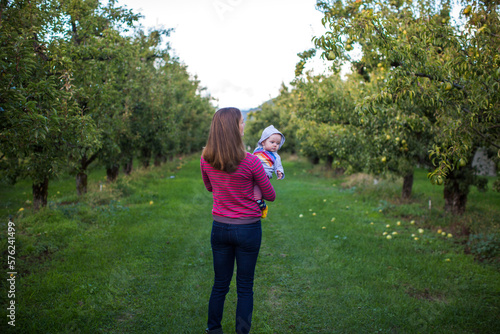 Mother with baby standing in orchard, Parkdale, Oregon, USA photo