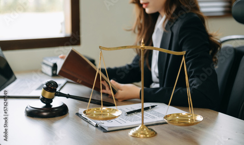 Photographie woman lawyer in the office with brass scale on wooden table