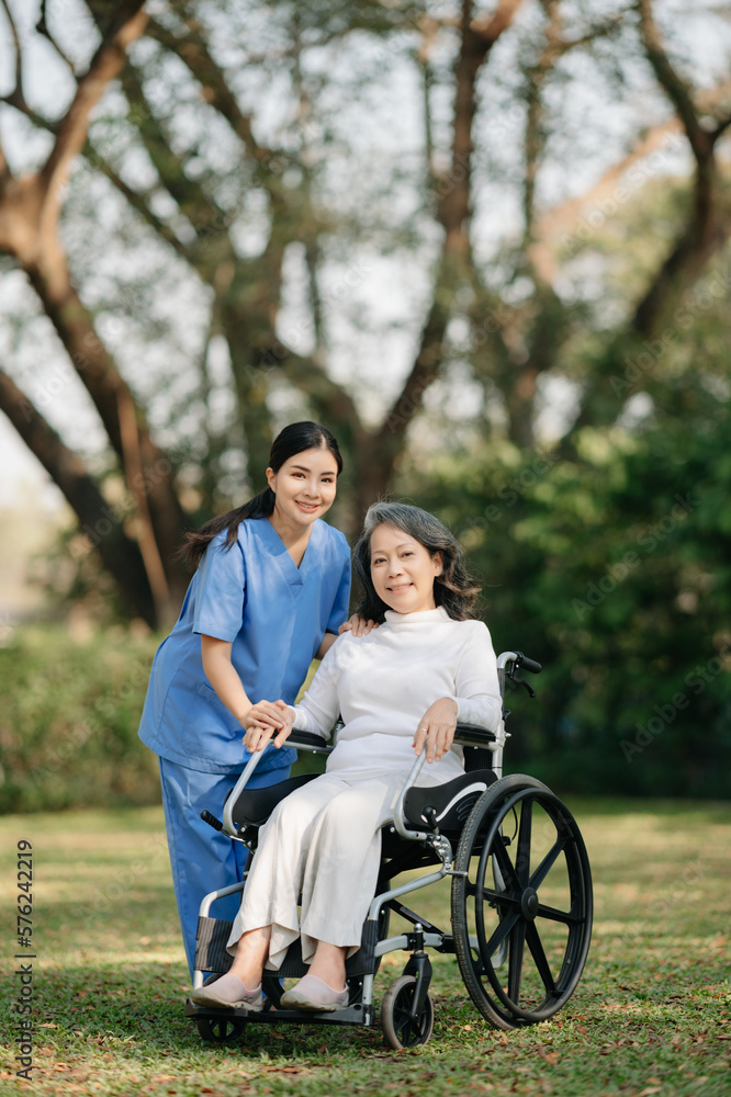 Elderly asian senior woman on wheelchair with Asian careful caregiver and encourage patient, walking in garden. with care from a caregiver and senior health insurance... Elderly asian senior woman on wheelchair with Asian careful caregiver and encourage patient, walking in garden. with care from a caregiver and senior health insurance...