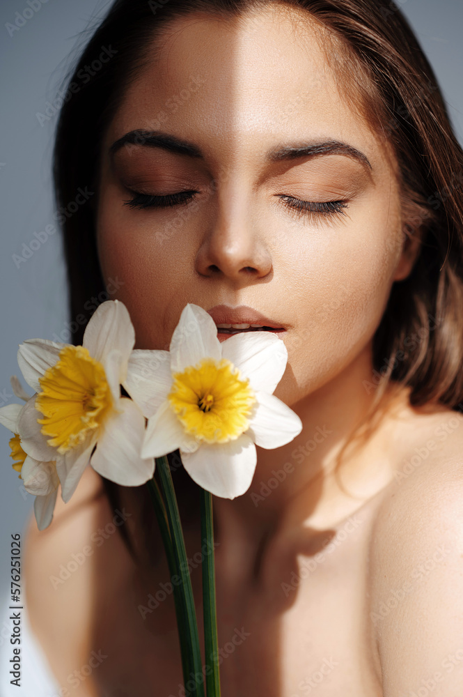 Half-naked brunette woman posing with narcissus flower Half-naked brunette woman posing with narcissus flower