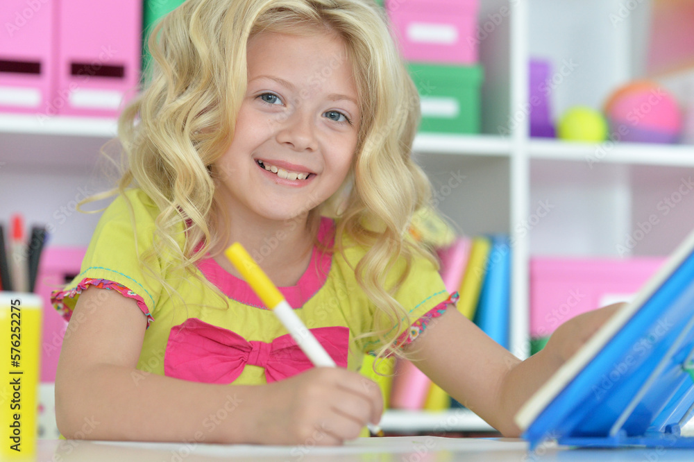 little girl studying at home at the table little girl studying at home at the table