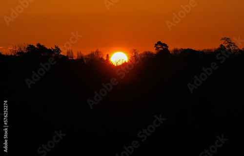 Sun rising up over a forest silhouette. Sunrise beautiful landscape photo.