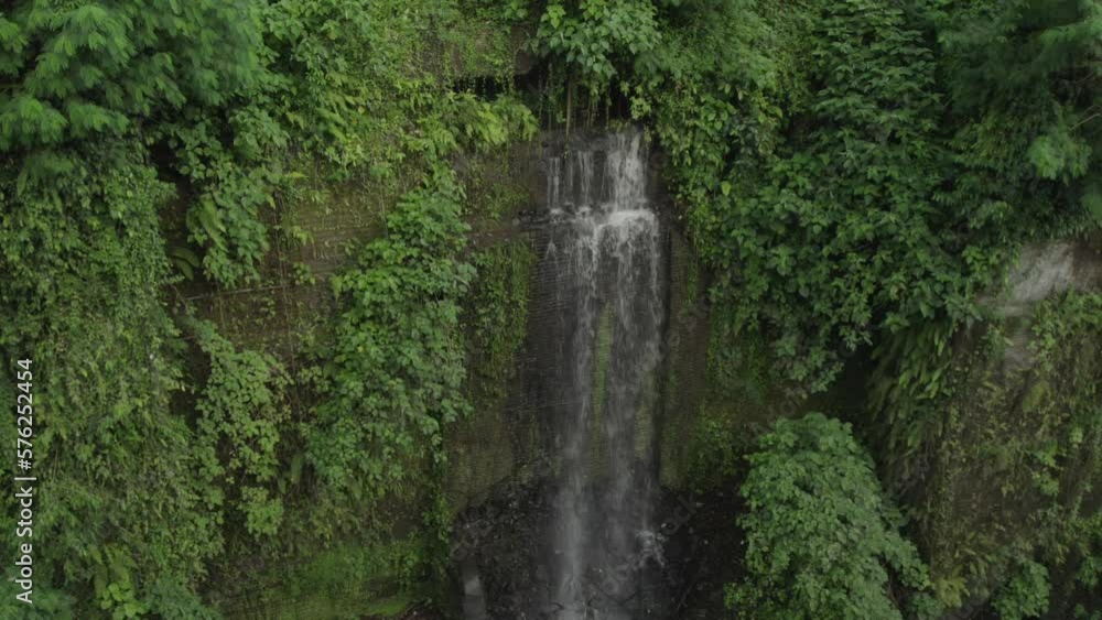 Secret waterfall hidden in the jungle near Ubud in Bali, Indonesia, drone pan right shot, close up view Secret waterfall hidden in the jungle near Ubud in Bali, Indonesia, drone pan right shot, close up view