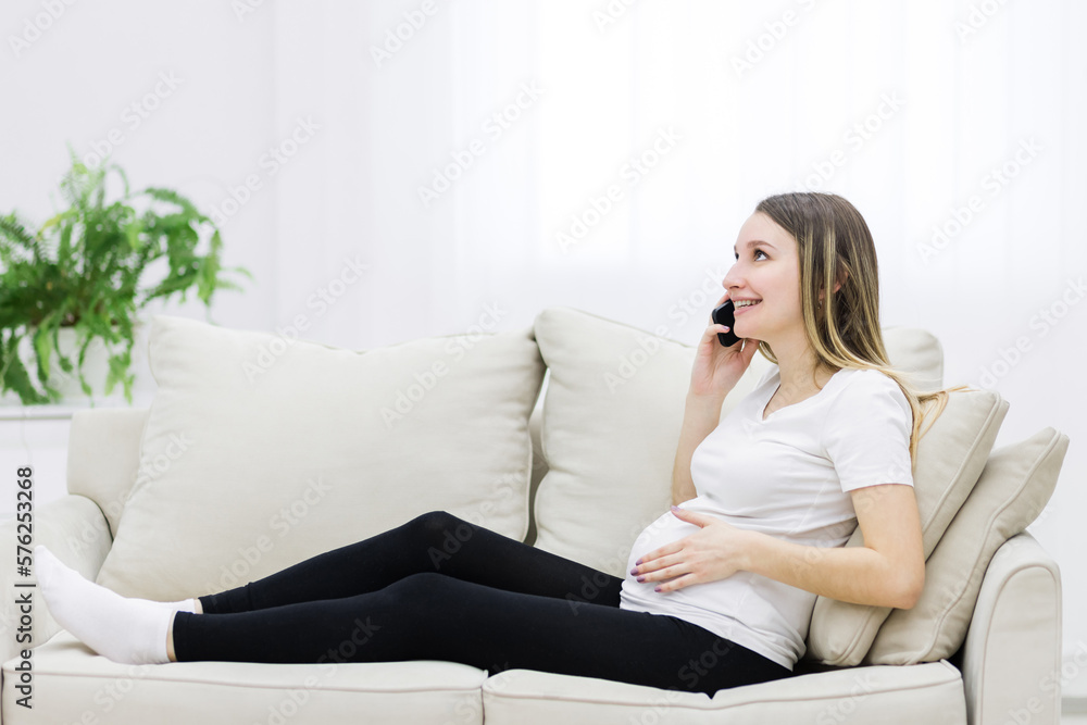 Side view of pregnant woman talking over the phone.