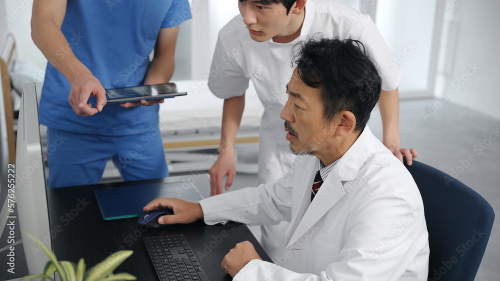 Obraz premium パソコンを見て会議する医療従事者のグループ