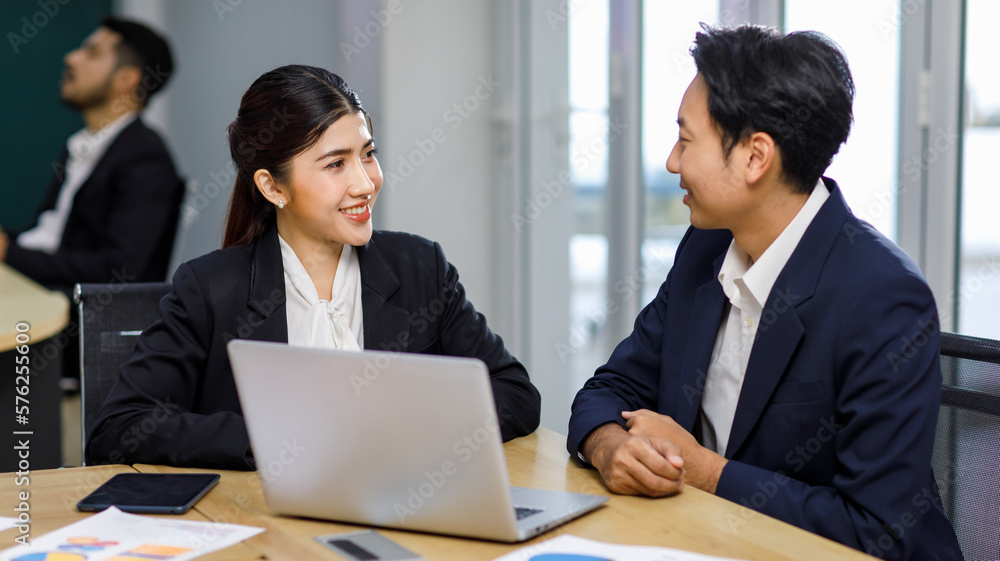 Millennial Asian professional successful male businessman manager mentor helping coaching advising new female businesswoman employee staff in formal business suit sitting working with laptop computer Millennial Asian professional successful male businessman manager mentor helping coaching advising new female businesswoman employee staff in formal business suit sitting working with laptop computer