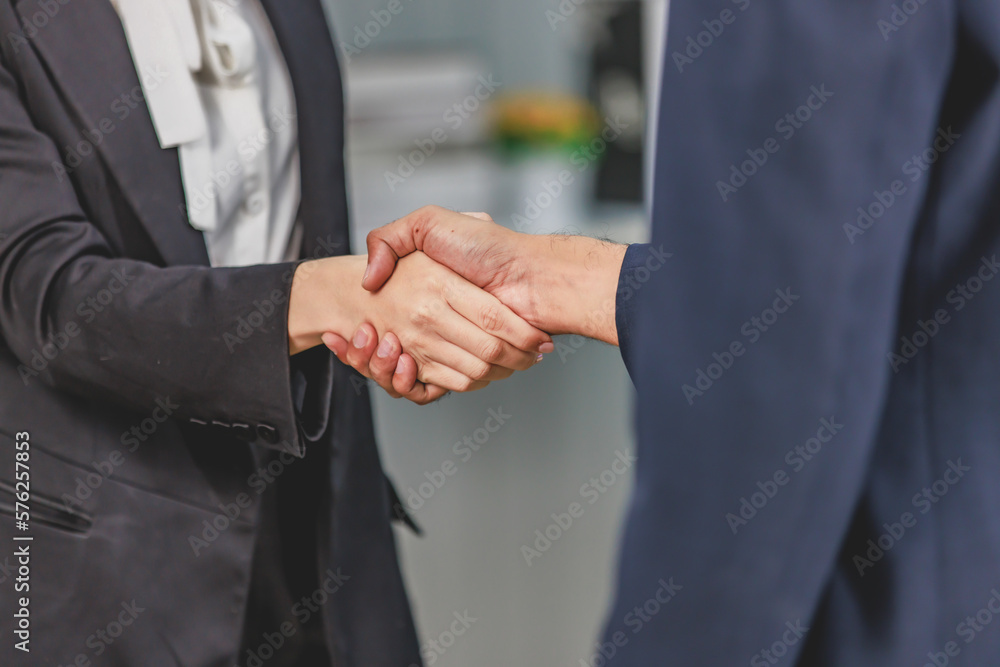 Closeup shot of Millennial unrecognizable unknown professional successful male businessman and female businesswoman in formal business suit shaking hands greeting deal done job agreement achievement
