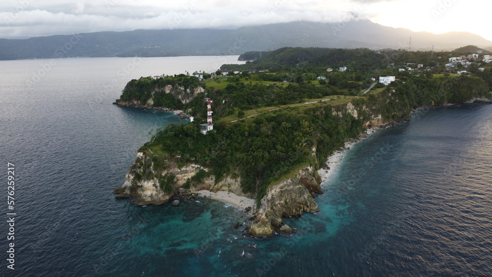 Aerial photography. View of the cape of a tropical island. Small lighthouse on the cliff.