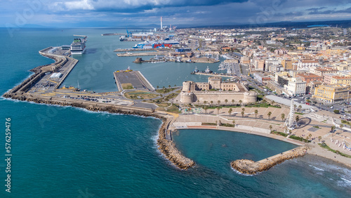 Panoramic view of the city of Civitavecchia with the adjoining tourist port and Forte Michelangelo. Emerald sea and view with tropical palm trees. Ferris wheel and cloudy sky.