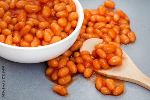 Selective focus close-up of baked beans with wooden spoon