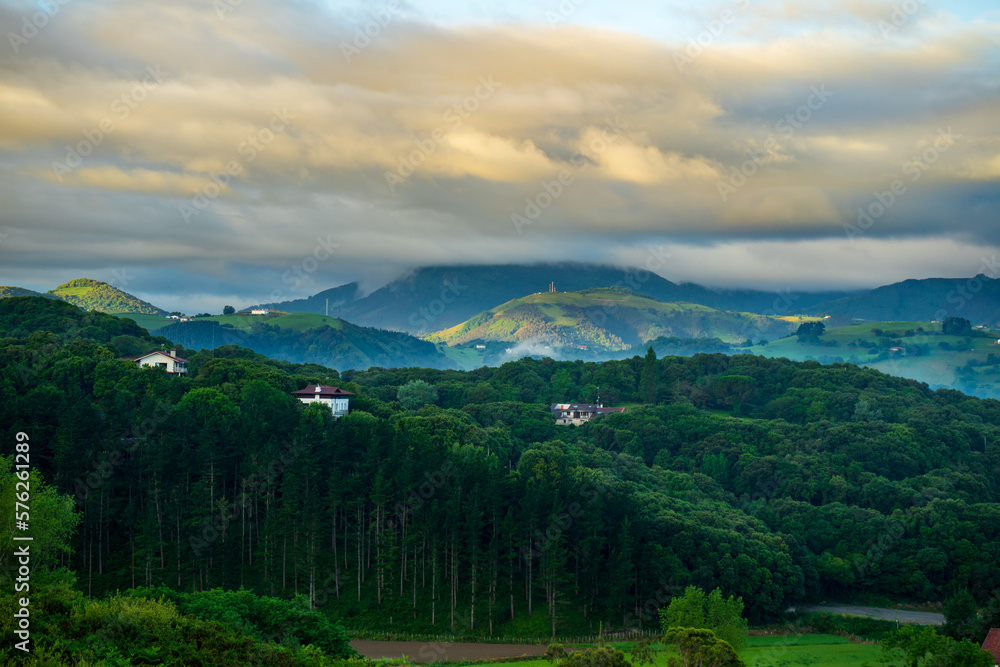 landscape with forest and mountains, mountain peaks in the clouds. Basque Country, Spain