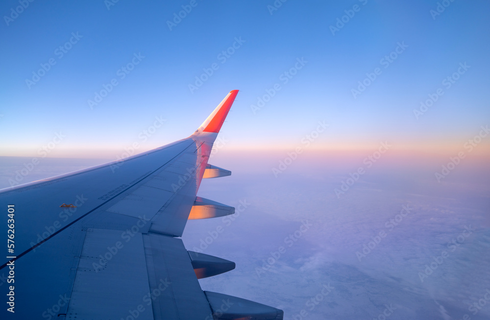 Airplane flying in the sky, view to thу aircraft wing through a window