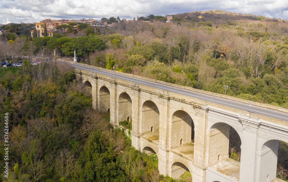 Aerial view of the monumental bridge and viaduct of Ariccia, Italy. It is a little city of Castelli Romani, in the metropolitan area of Rome. There are no cars on the road.