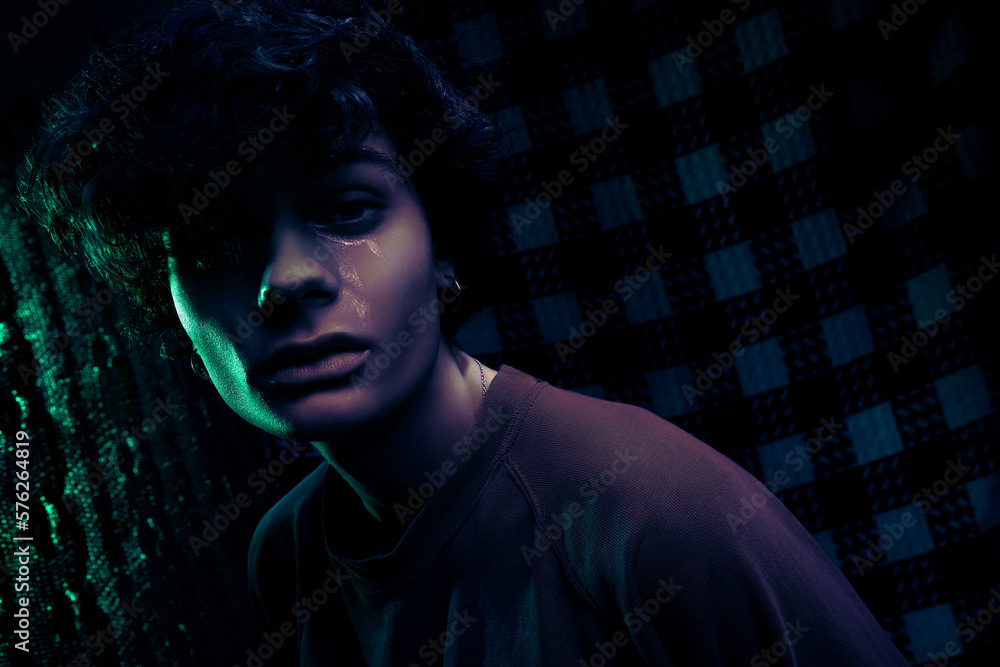 Sad teenager with glitter traces of tears on face in dark room Sad teenager with glitter traces of tears on face in dark room