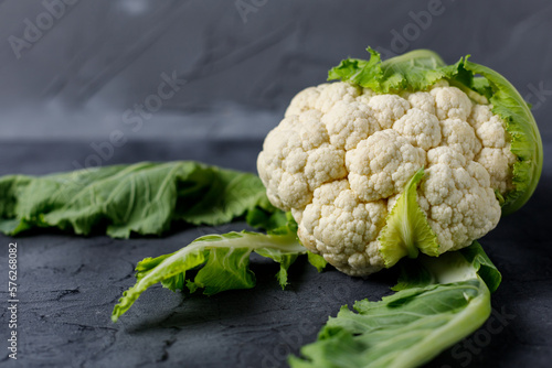 Fresh raw whole cauliflower on black table. Organic healthy food. Copy space