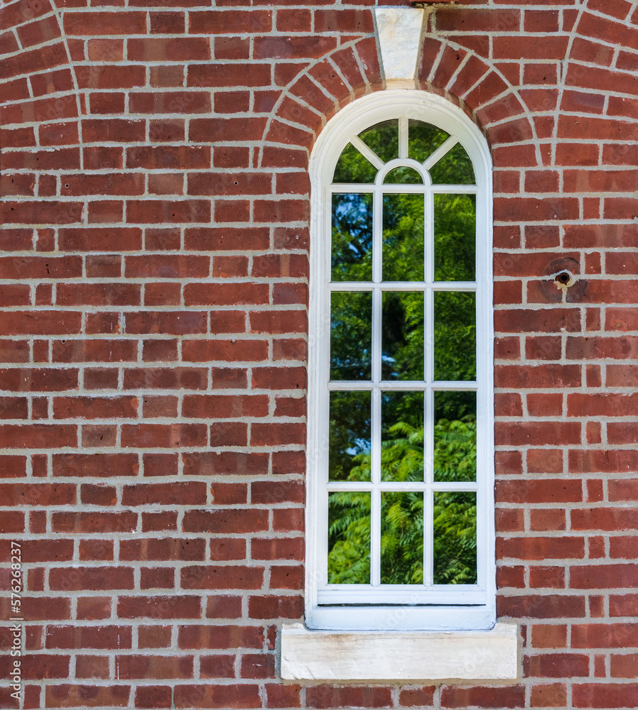 New arched window in a brick wall with keystone top center. With arched brick detail. new custom energy efficient window built to match the original design Wood frame window at an ivy league collage New arched window in a brick wall with keystone top center. With arched brick detail. new custom energy efficient window built to match the original design Wood frame window at an ivy league collage