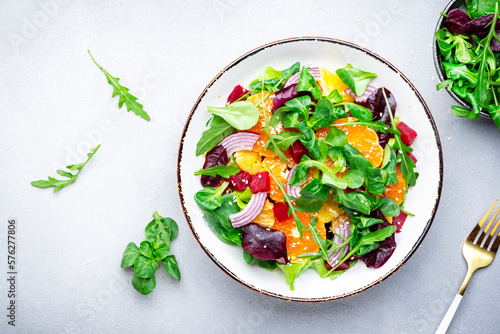 Εκτύπωση καμβά Beet and orange healthy salad with arugula, lamb lettuce, red onion, walnut and tangerine, gray kitchen table