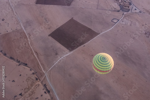 Hot air balloon seen from above flying over the desert fields of morocco near marrakech